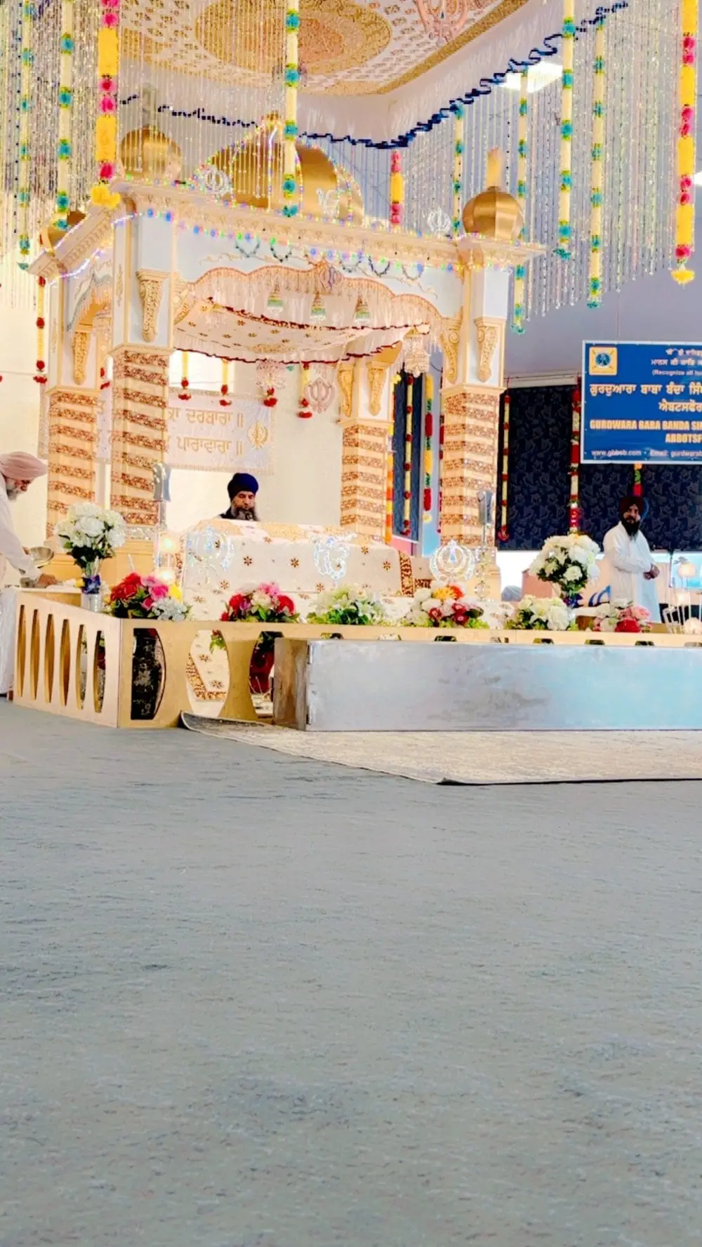 Low-angle view of the decorated palki area with floral arrangements and embroidered cloth.
