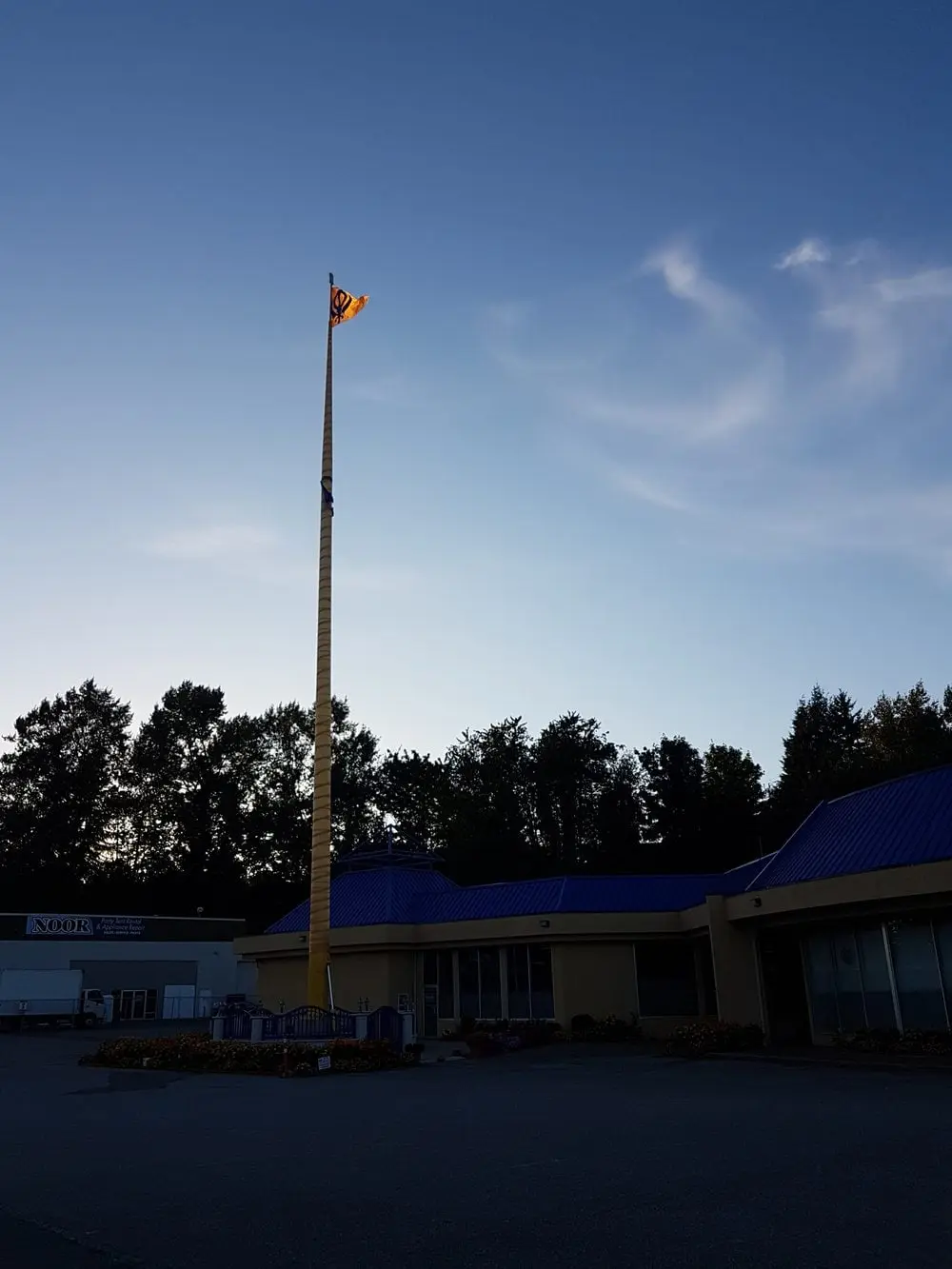 Outdoor view of the Nishan Sahib flagpole against the sky.