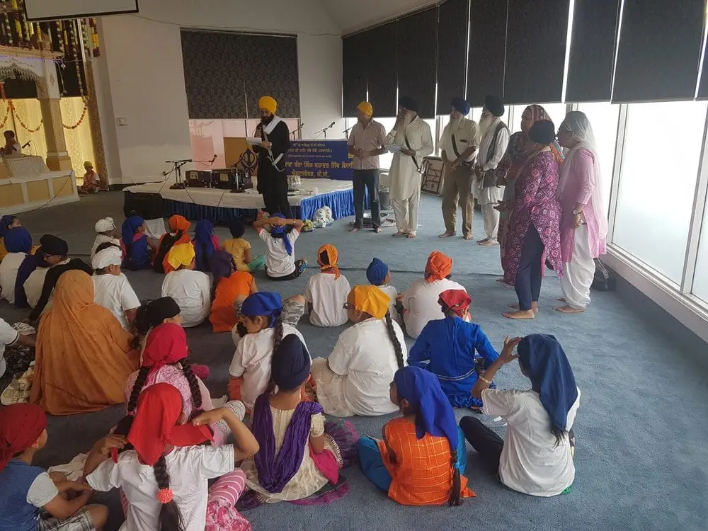 Congregants seated near windows while visitors move through the hall.