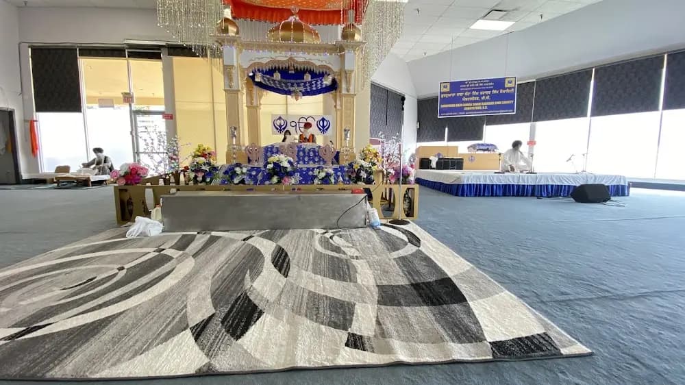 Wide prayer hall view with patterned carpet leading to the altar.