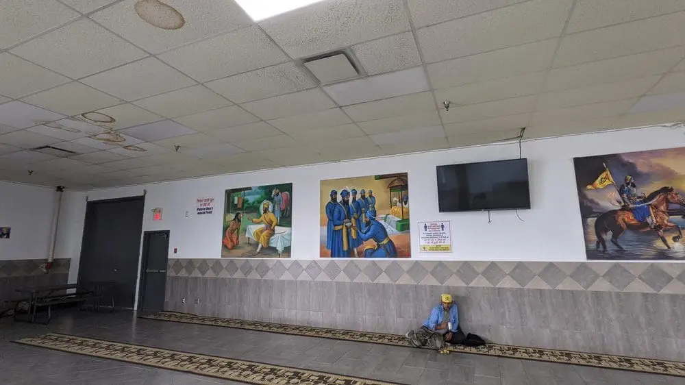 Interior hallway wall with artwork and a seated child.