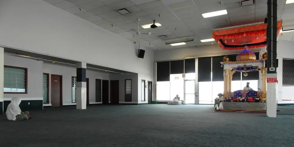 Quiet corner of the prayer hall with doors and open floor space.