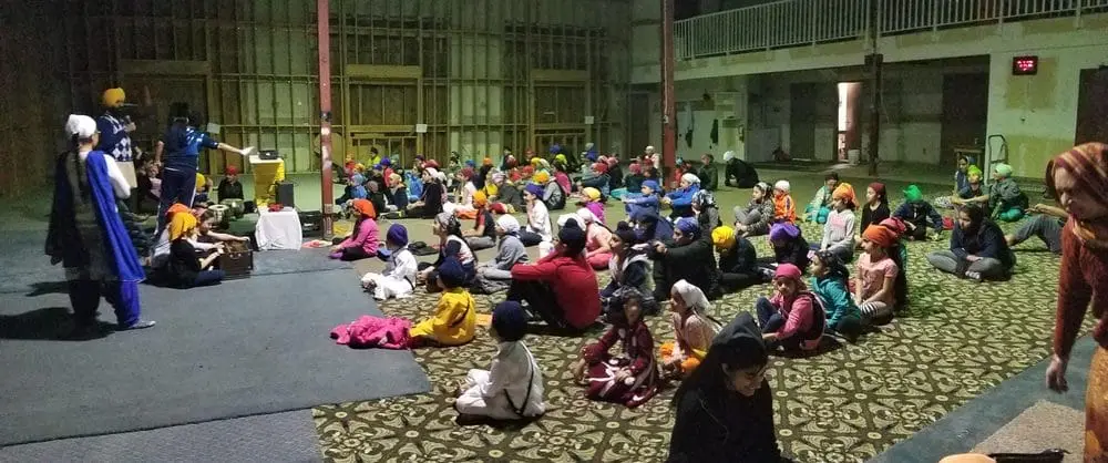 Large community gathering seated for a program in the hall.